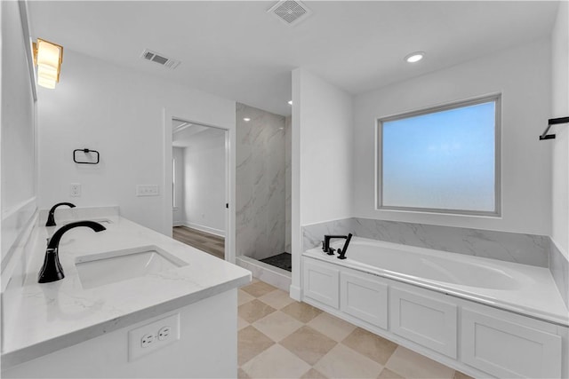 bathroom with a bath, visible vents, a marble finish shower, and a sink