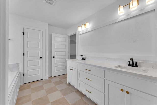 bathroom with a sink, visible vents, double vanity, and tile patterned floors