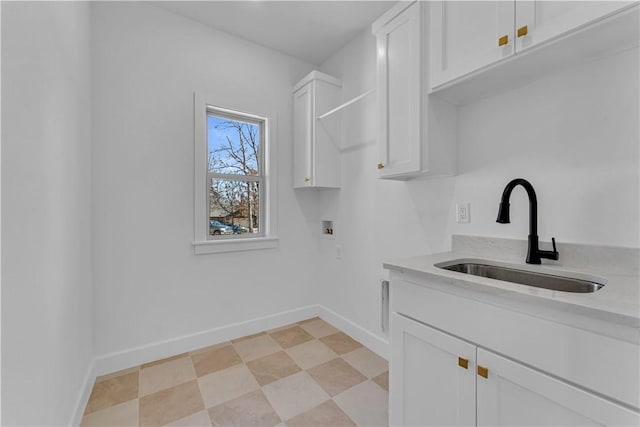 washroom with light floors, baseboards, cabinet space, a sink, and washer hookup