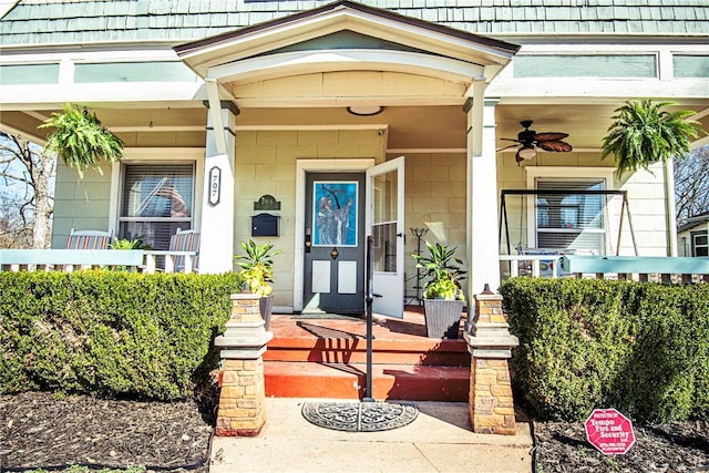 doorway to property featuring covered porch and ceiling fan