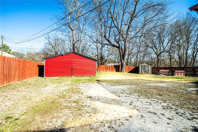 view of yard with an outbuilding, a storage shed, and a fenced backyard