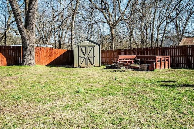 view of yard featuring an outbuilding, a storage shed, and a fenced backyard