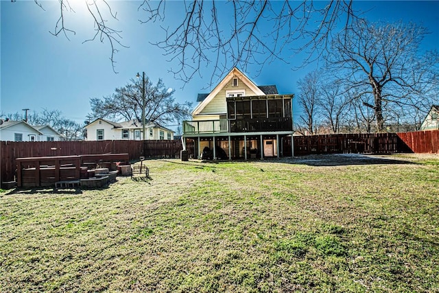 back of property with a lawn, a fenced backyard, and a sunroom