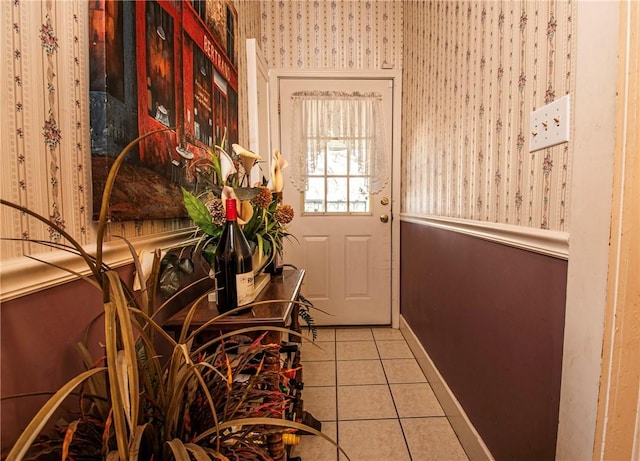 doorway to outside with baseboards and tile patterned flooring