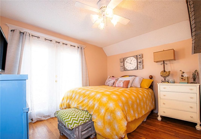 bedroom featuring ceiling fan, a textured ceiling, lofted ceiling, and wood finished floors