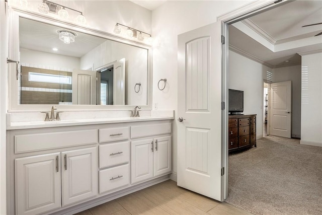 full bath featuring ceiling fan, crown molding, double vanity, and a sink