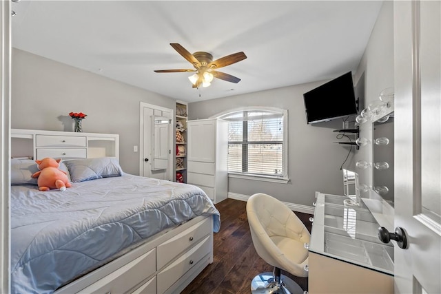 bedroom with dark wood-type flooring, baseboards, a closet, and ceiling fan