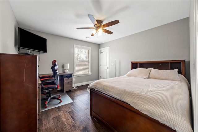 bedroom with baseboards, ceiling fan, and dark wood-style flooring