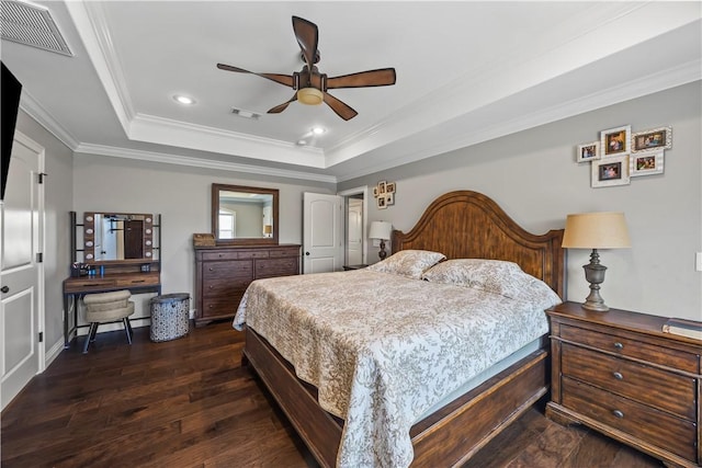 bedroom featuring dark wood finished floors, visible vents, a raised ceiling, and ornamental molding