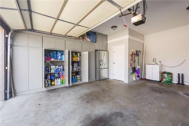 garage featuring a garage door opener and stainless steel refrigerator with ice dispenser