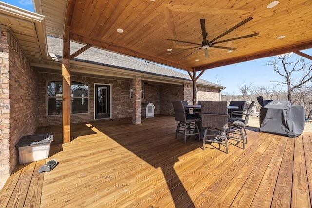 deck featuring outdoor dining space, grilling area, and ceiling fan