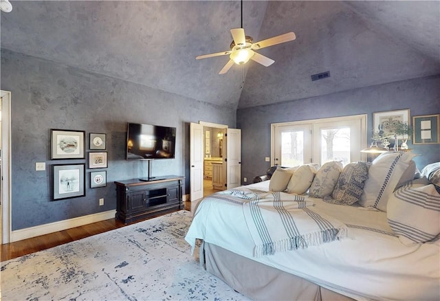 bedroom featuring a ceiling fan, wood finished floors, visible vents, baseboards, and vaulted ceiling