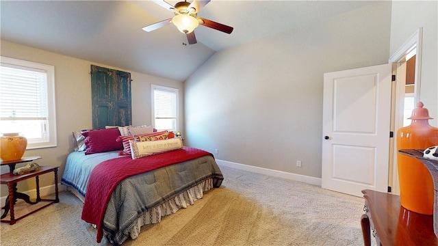 carpeted bedroom featuring lofted ceiling, multiple windows, a ceiling fan, and baseboards