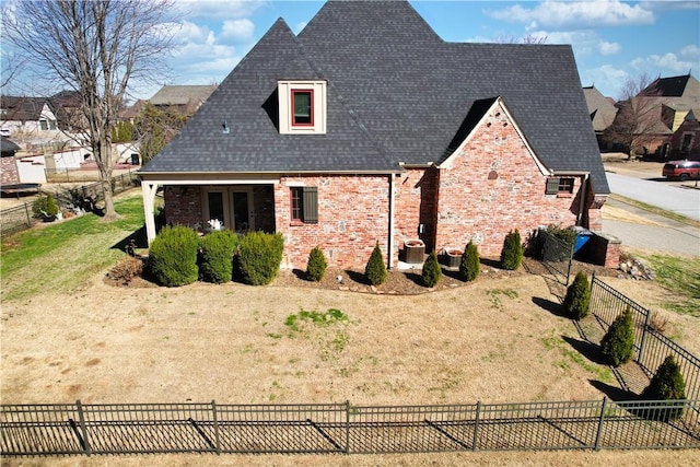 view of side of property with fence, central AC, a shingled roof, a lawn, and brick siding