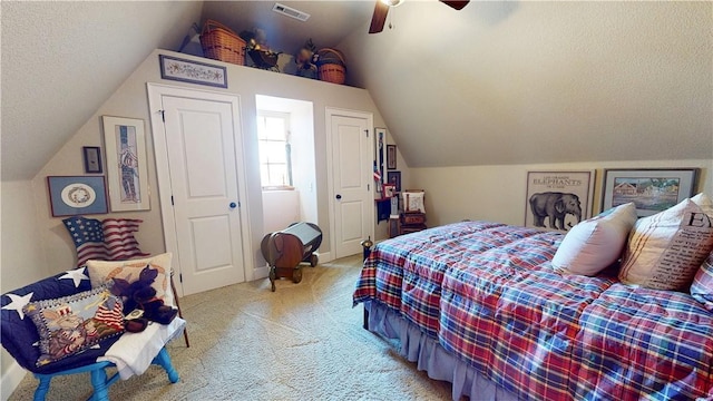 carpeted bedroom featuring visible vents, a textured ceiling, lofted ceiling, and a ceiling fan