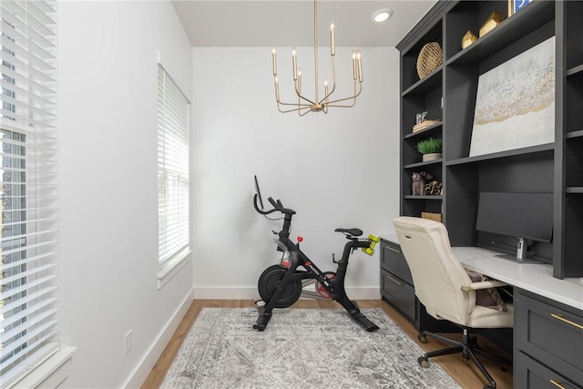 home office featuring a notable chandelier, baseboards, and light wood-type flooring