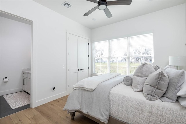 bedroom with visible vents, baseboards, ceiling fan, light wood-style floors, and a closet