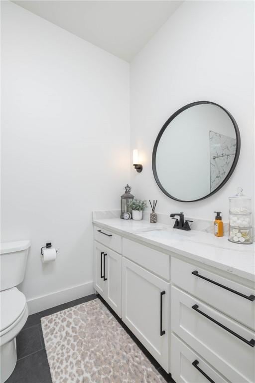 bathroom with vanity, tile patterned floors, toilet, and baseboards