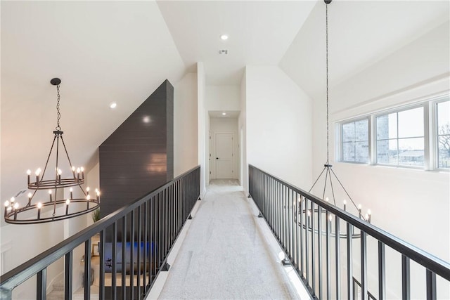 hallway with light colored carpet, an upstairs landing, and a notable chandelier