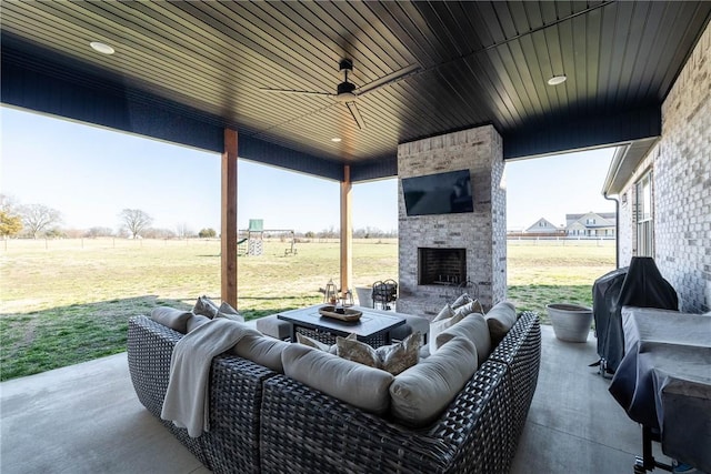 view of patio featuring a grill, ceiling fan, and an outdoor living space with a fireplace