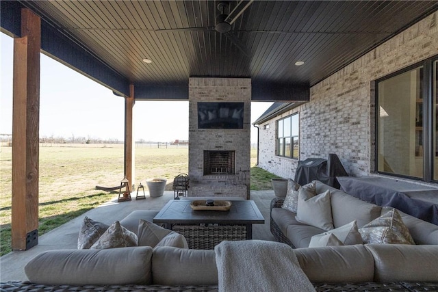 view of patio with an outdoor living space with a fireplace