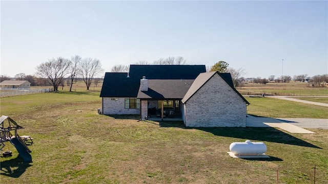 exterior space featuring a rural view, a lawn, and a chimney