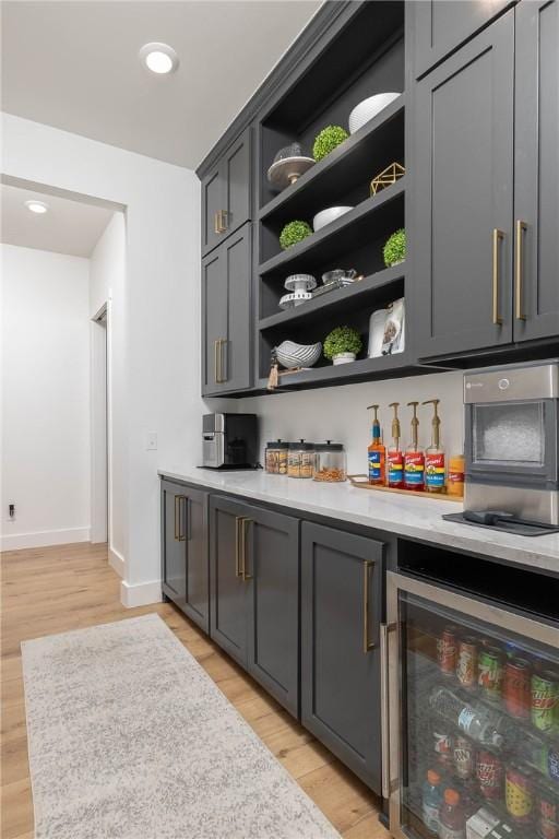 bar featuring recessed lighting, light wood-type flooring, baseboards, and beverage cooler