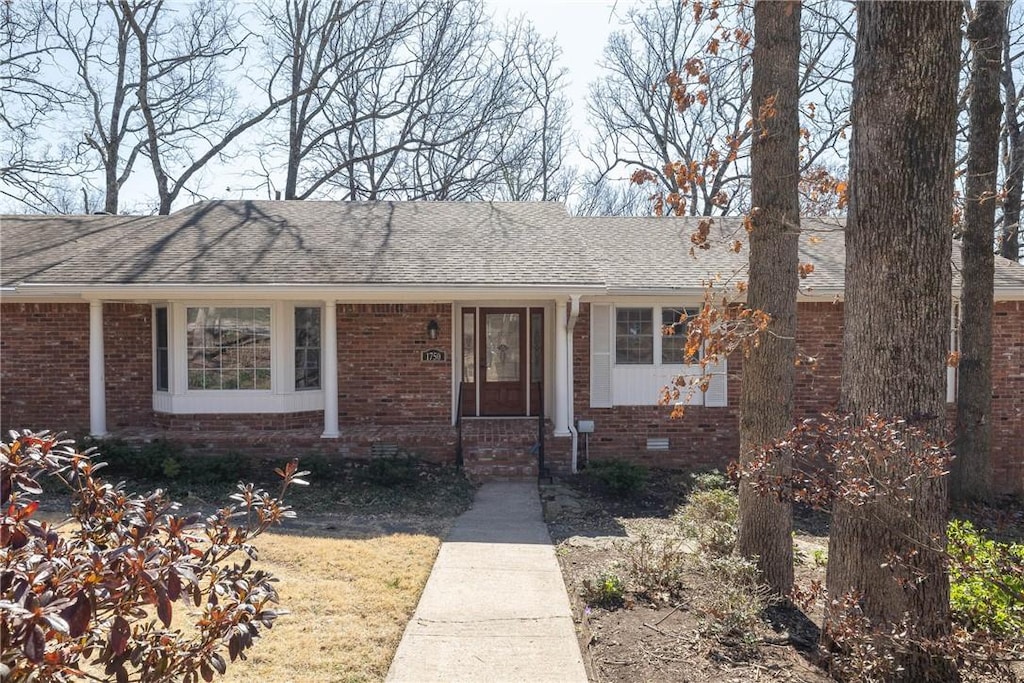 view of front of property with crawl space, brick siding, and a shingled roof