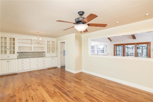 unfurnished living room with baseboards, light wood-style floors, crown molding, beamed ceiling, and ceiling fan with notable chandelier