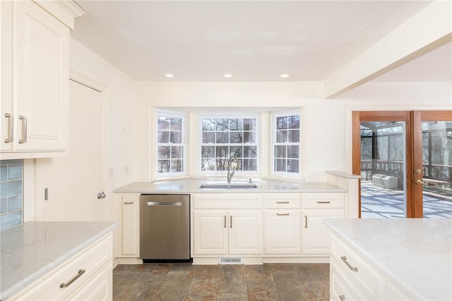 kitchen with a wealth of natural light, dishwasher, light stone countertops, and a sink