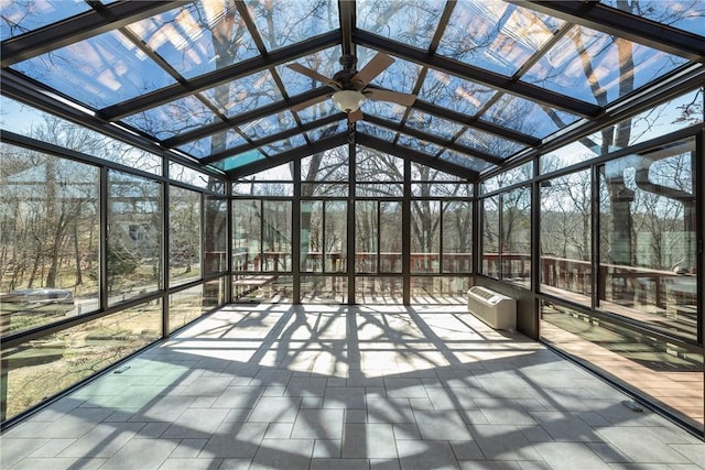 unfurnished sunroom with plenty of natural light, a ceiling fan, and a wall unit AC