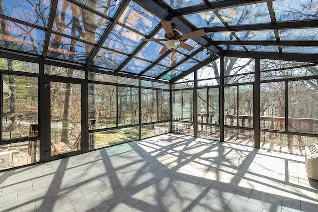 unfurnished sunroom with lofted ceiling and a ceiling fan