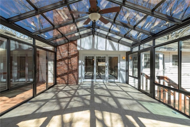 unfurnished sunroom with lofted ceiling with skylight and a ceiling fan