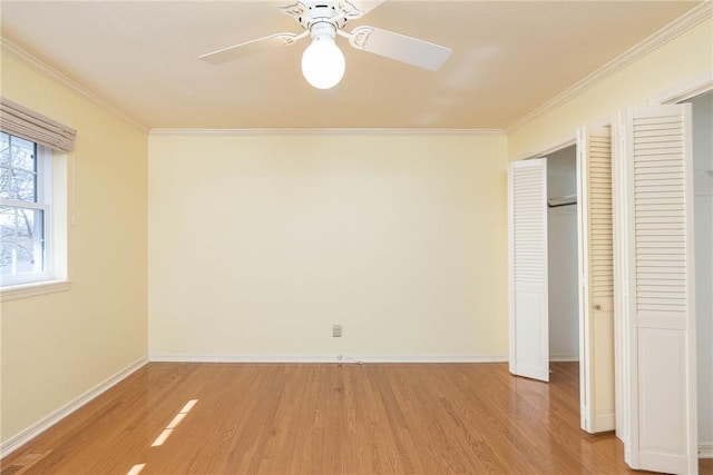 unfurnished bedroom featuring baseboards, crown molding, and light wood finished floors