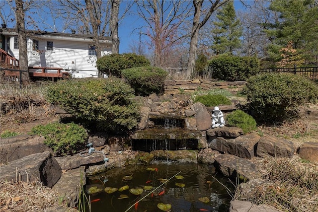 view of yard with a garden pond and fence