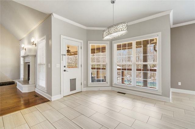 unfurnished dining area featuring visible vents, crown molding, baseboards, and wood finished floors