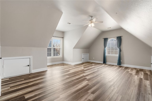 bonus room with visible vents, baseboards, a healthy amount of sunlight, and wood finished floors