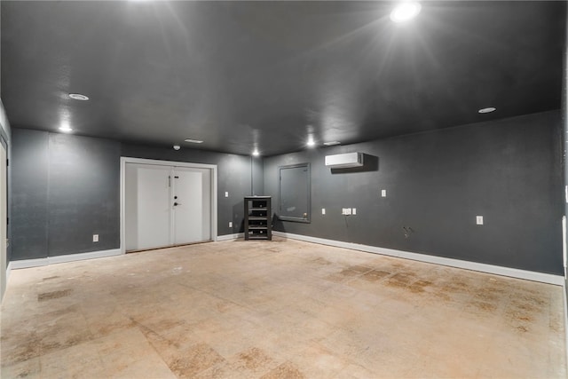 garage with a wall mounted air conditioner and baseboards