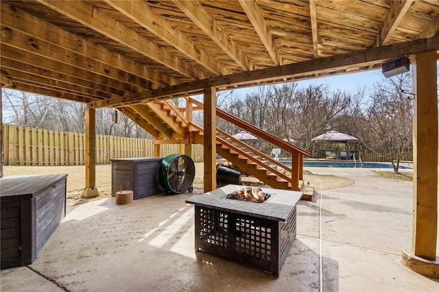 view of patio with stairs, a fenced in pool, a fire pit, and fence