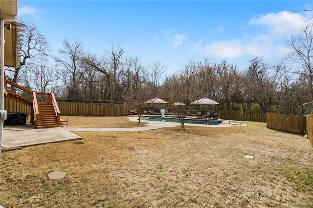 view of yard with a patio area, a fenced in pool, stairs, and a fenced backyard