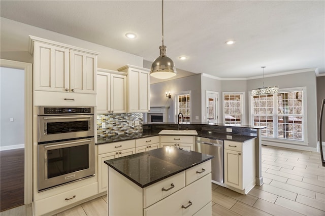 kitchen with a peninsula, dark stone counters, a sink, decorative backsplash, and stainless steel appliances