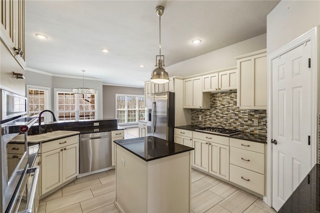 kitchen with backsplash, a center island, cream cabinets, stainless steel appliances, and a sink