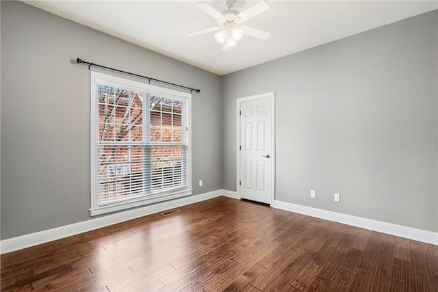 unfurnished room featuring visible vents, baseboards, dark wood-style flooring, and ceiling fan