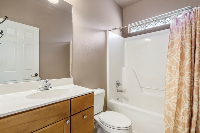 bathroom with vanity, toilet, shower / tub combo with curtain, and a textured wall