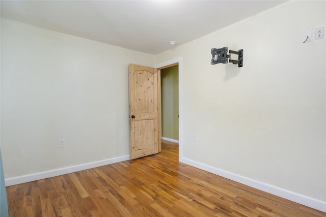 empty room with baseboards and light wood-type flooring