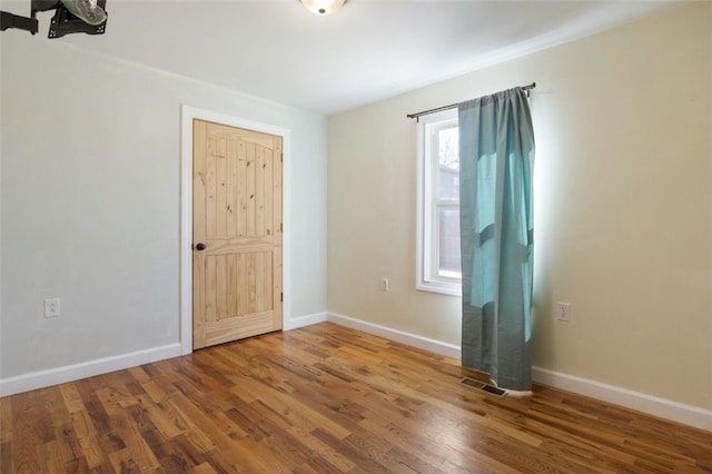 unfurnished room featuring baseboards and wood finished floors