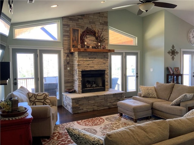 living area with a wealth of natural light, dark wood-type flooring, high vaulted ceiling, and a ceiling fan