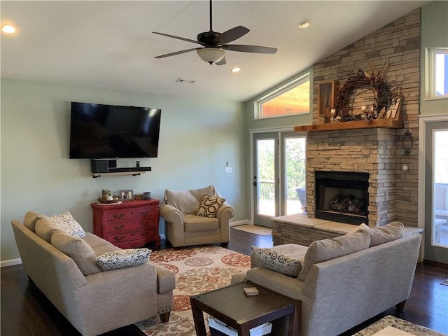 living area with visible vents, dark wood-type flooring, a ceiling fan, a fireplace, and vaulted ceiling