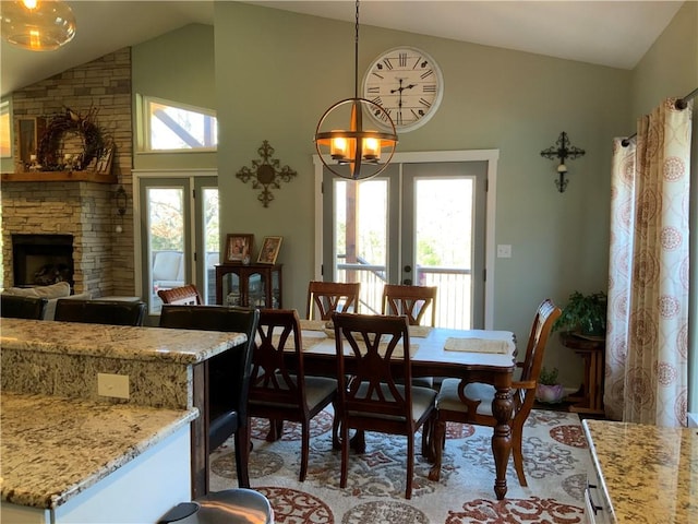 dining room with a wealth of natural light, french doors, a chandelier, and a fireplace