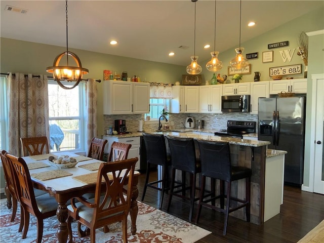 dining space featuring visible vents, recessed lighting, lofted ceiling, a chandelier, and dark wood-style flooring